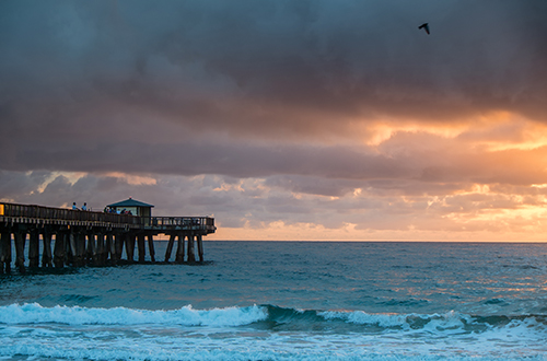 photo of a pier under stormy skies