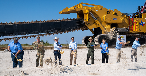 people standing in front of heavy machinery