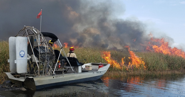 Boat monitoring a fire near the water's edge