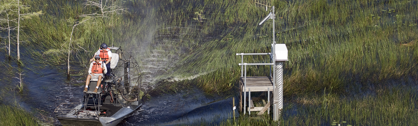 employees on airboat checking monitoring station