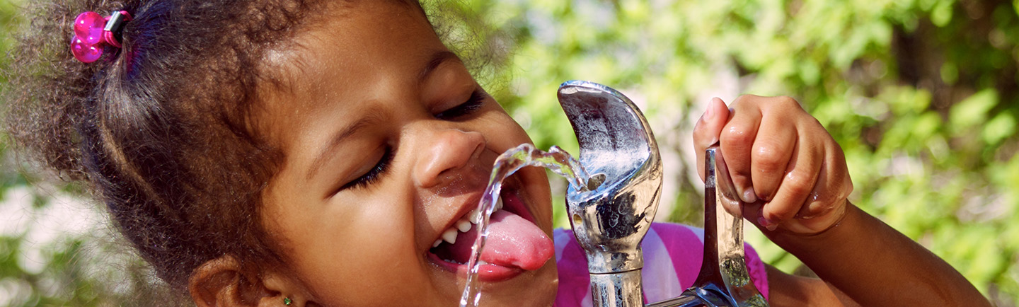 girl drinking from water fountain