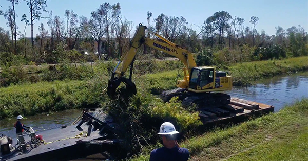 tractor removing debris from canal