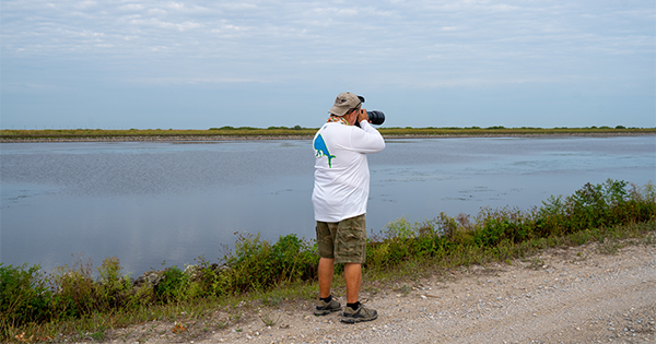 man photographing distant object