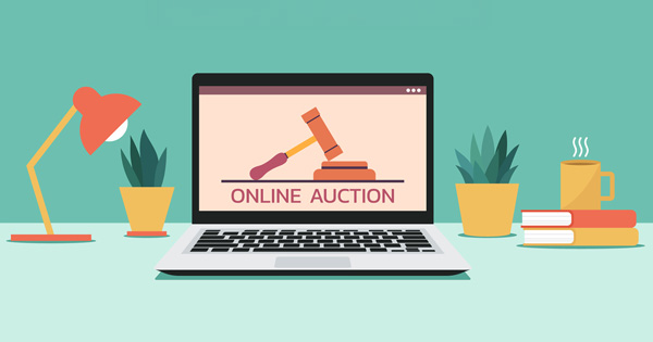 Laptop displaying auction gavel with desk items