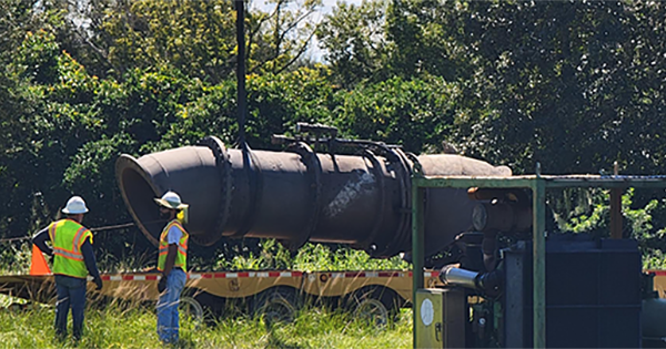 workers standing near pipe structure