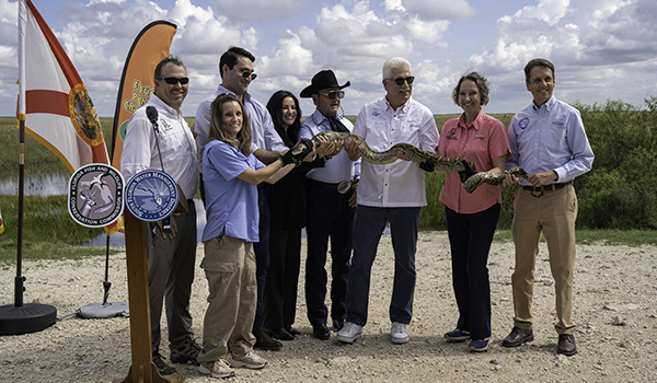 group of people holding a python