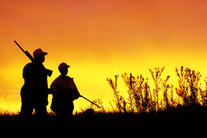 Two people hunting at sunset.