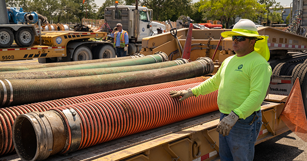 sfwmd employee standing next to large tube