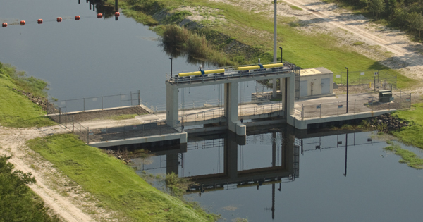 Aerial view of a water control structure with access roads along both banks